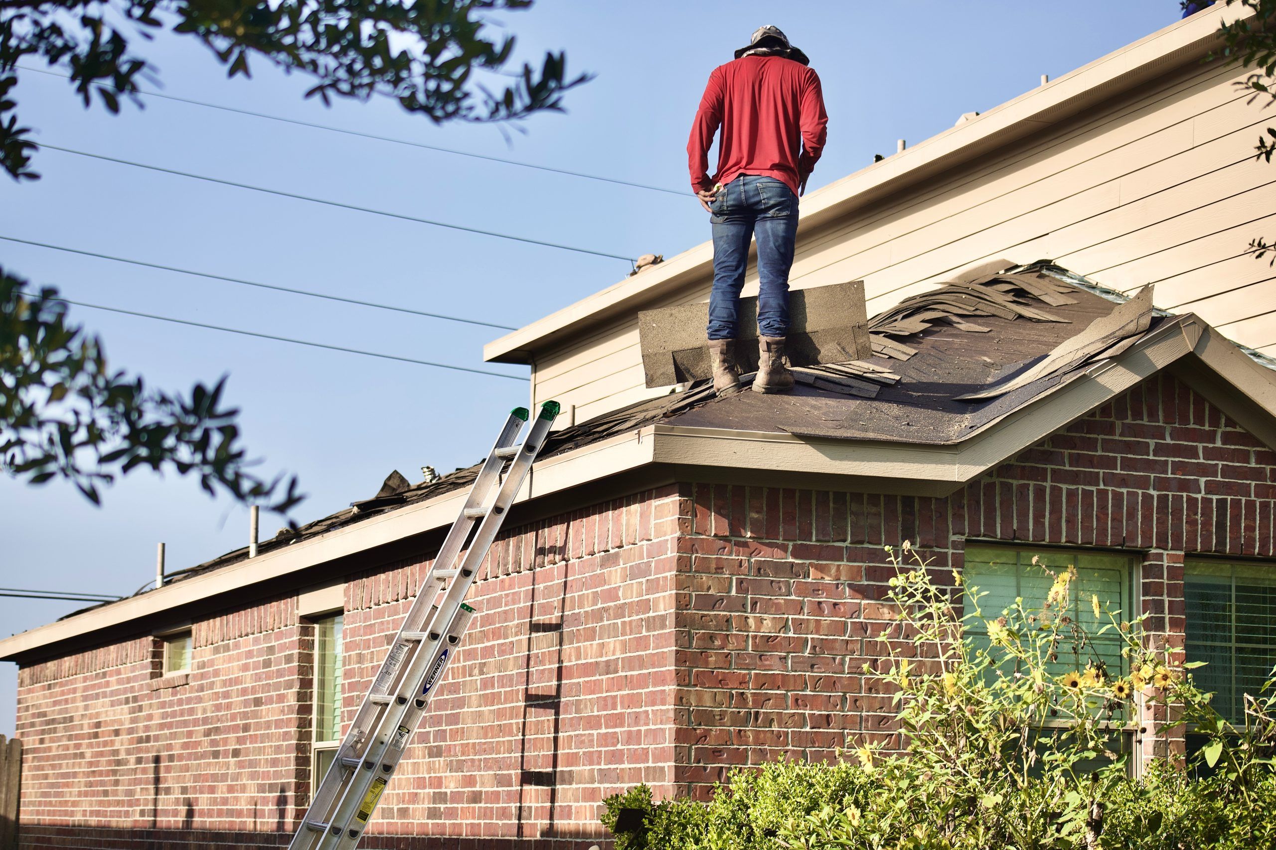 roofer on roof inspecting damage