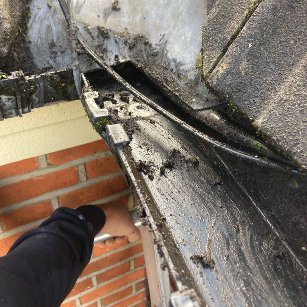 worker cleaning gutter 