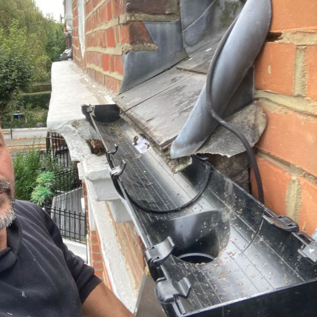 roofer on ladder cleaning fascia and soffits