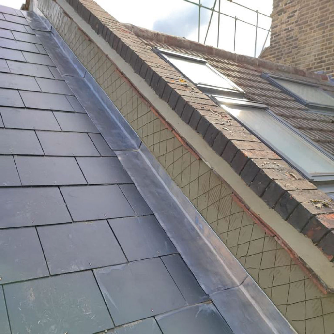 rendering and masonry work in progress against slate roof
