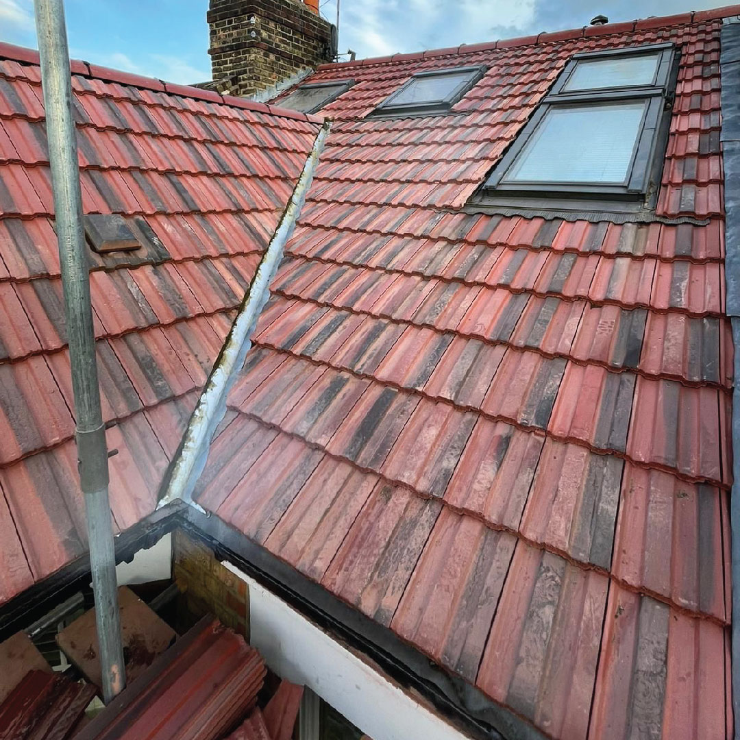 red pitched roof with scaffolding and new tiles 