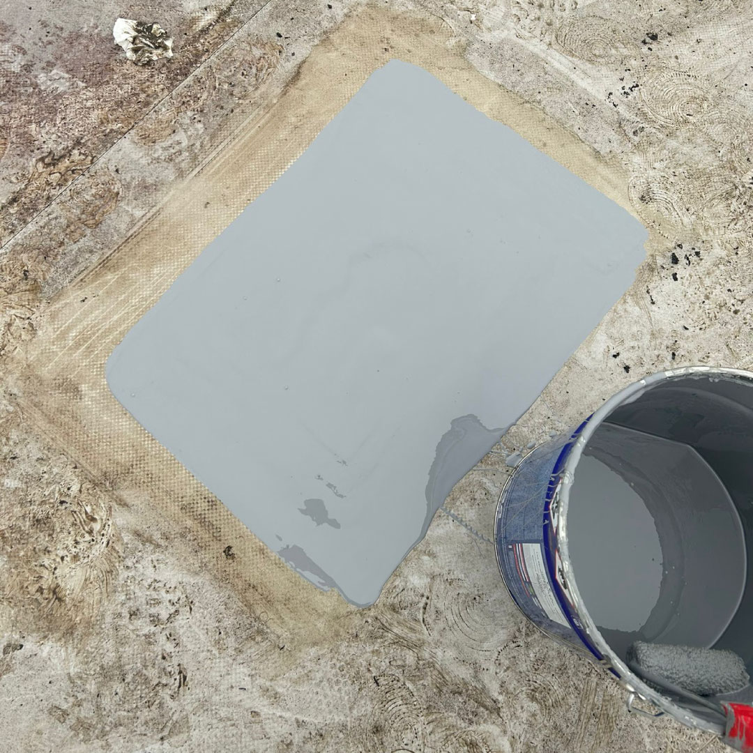 hole in flat roof repaired with grey liquid membrane