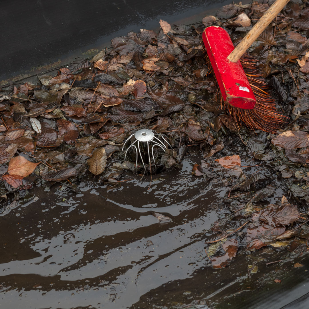 red sweeper brush cleaning leaves and debris