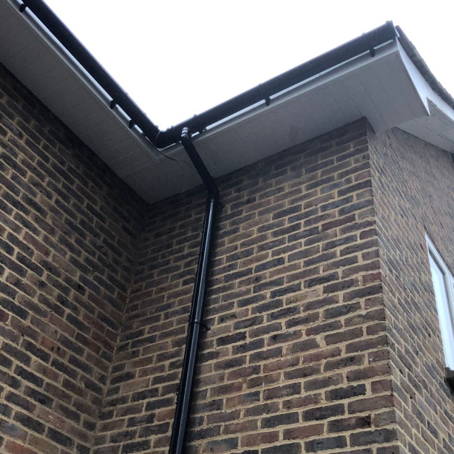 uPVC gutter replacement and downpipe on brown brick house