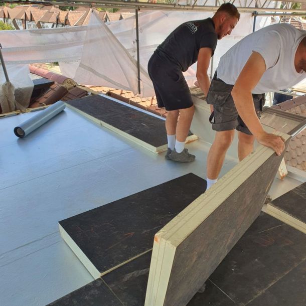 two roofers installing a warm roof